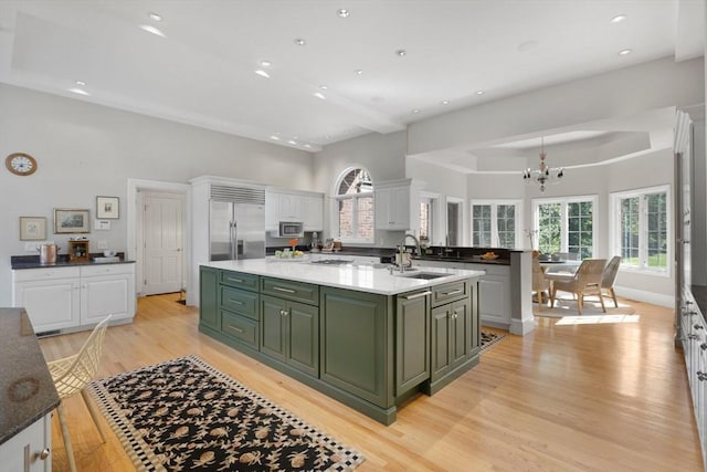 11 Fairway Dr, Andover, MA 01810 - kitchen with green cabinets, a kitchen island with sink, white cabinets, a chandelier, and light wood-style floors
