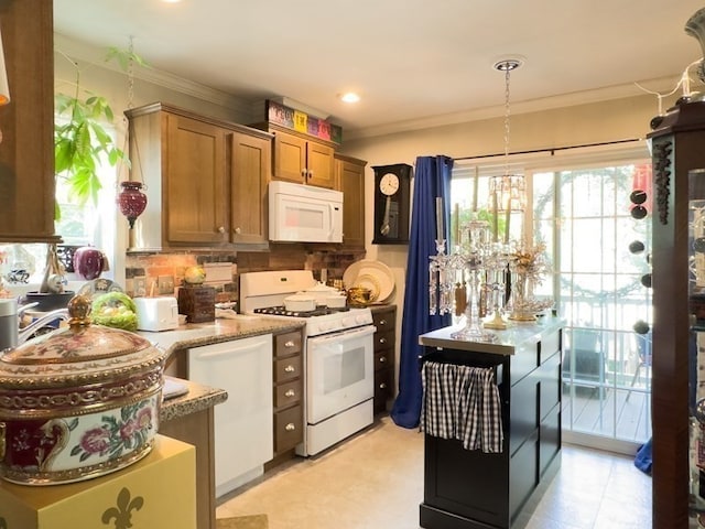 kitchen with white appliances, ornamental molding, light stone countertops, and plenty of natural light