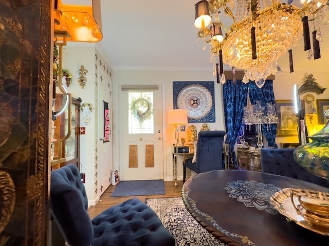 entrance foyer featuring an inviting chandelier, wood-type flooring, and ornamental molding