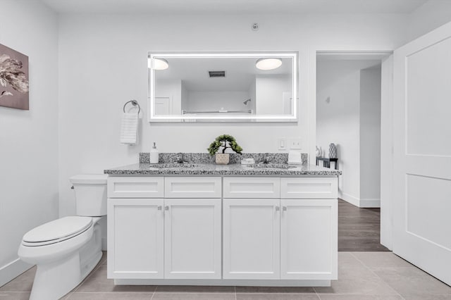 bathroom featuring wood-type flooring, vanity, and toilet