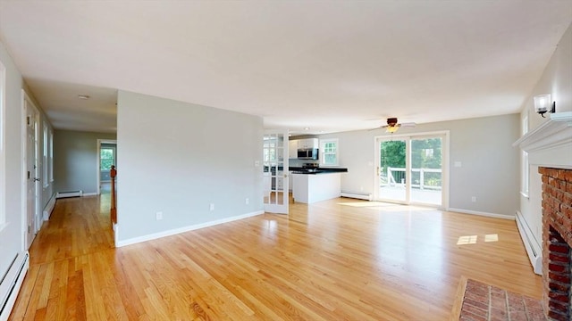 12 Prouty Ln, Rutland, MA 01543 - unfurnished living room with a fireplace, a baseboard heating unit, a baseboard radiator, and light wood-type flooring