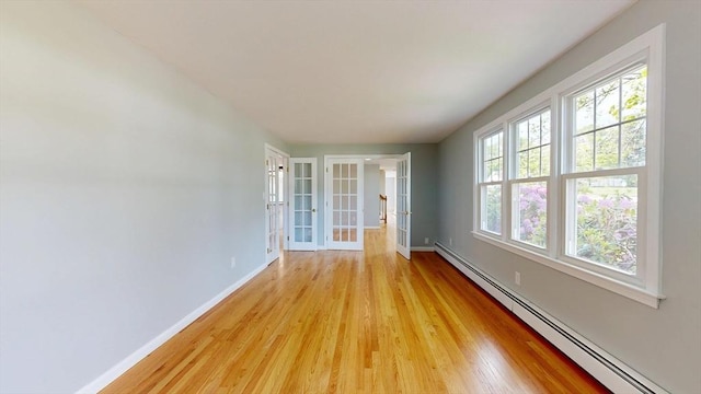 12 Prouty Ln, Rutland, MA 01543 - empty room featuring a baseboard radiator, baseboards, light wood-style floors, and french doors