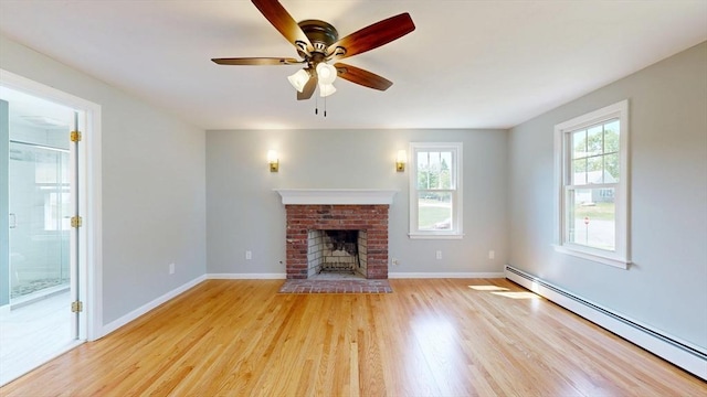 12 Prouty Ln, Rutland, MA 01543 - unfurnished living room featuring a baseboard heating unit, light wood-type flooring, ceiling fan, a fireplace, and baseboards