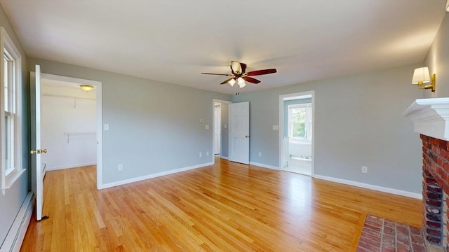 12 Prouty Ln, Rutland, MA 01543 - unfurnished living room with a baseboard radiator, a ceiling fan, a brick fireplace, light wood-style floors, and baseboards