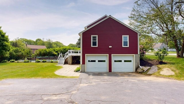 12 Prouty Ln, Rutland, MA 01543 - view of home's exterior featuring driveway, an attached garage, a lawn, and stairs