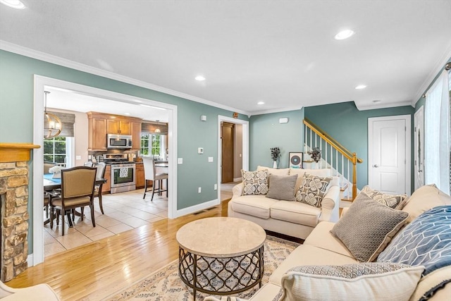 169 Braeburn Rd, East Longmeadow, MA 01128 - living area featuring stairs, crown molding, light wood-style flooring, recessed lighting, and a stone fireplace