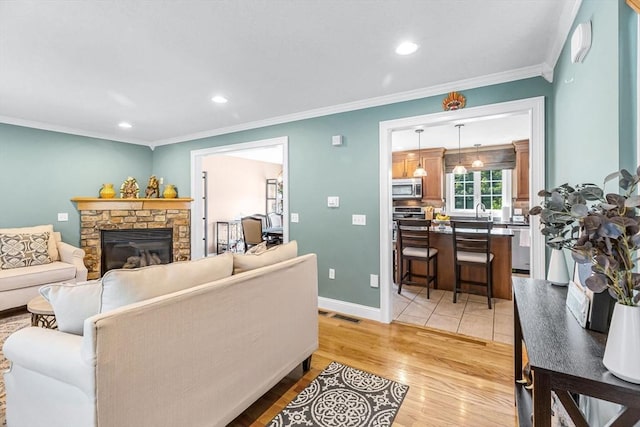 169 Braeburn Rd, East Longmeadow, MA 01128 - living room featuring ornamental molding, a fireplace, light wood-type flooring, recessed lighting, and baseboards