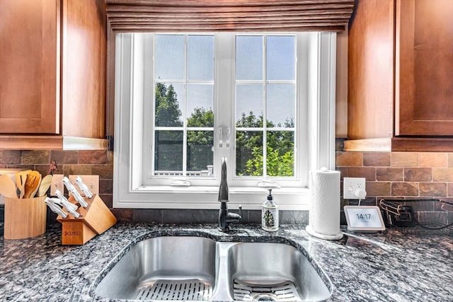 169 Braeburn Rd, East Longmeadow, MA 01128 - kitchen view of a sink, dark stone countertops, tasteful backsplash, and brown cabinetry