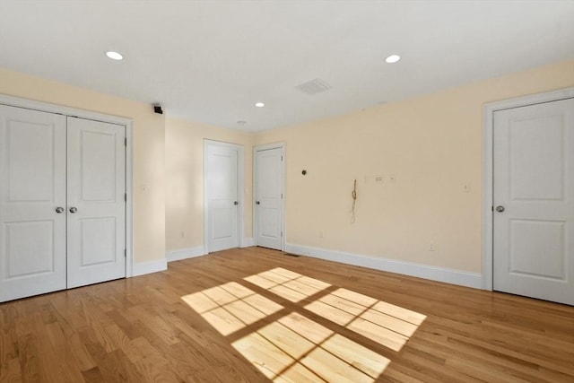 unfurnished bedroom with light wood finished floors, baseboards, and recessed lighting