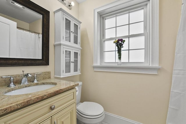 full bath with vanity, toilet, and baseboards