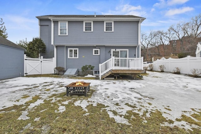 snow covered property with fence private yard, a gate, and an outdoor fire pit