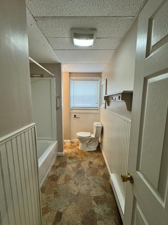 16 Richards Ave Unit 106, North Attleboro, MA 02760 - full bathroom featuring toilet, shower / tub combination, a wainscoted wall, stone finish floor, and a paneled ceiling
