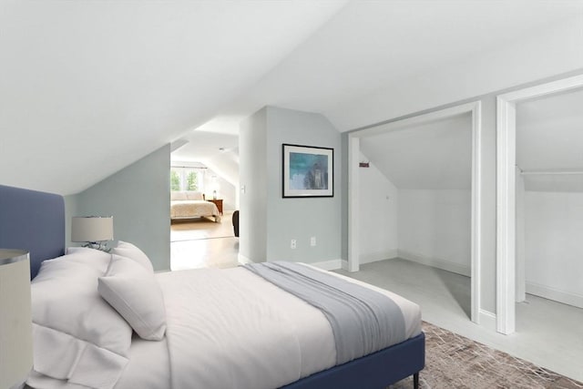 carpeted bedroom featuring vaulted ceiling and baseboards
