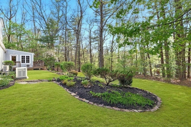 view of grassy yard with a deck and central AC