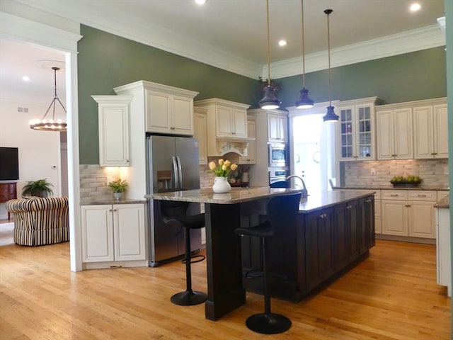 99 Elizabeth St, Agawam, MA 01030 - kitchen featuring appliances with stainless steel finishes, light wood finished floors, tasteful backsplash, recessed lighting, and crown molding