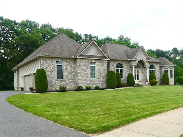 99 Elizabeth St, Agawam, MA 01030 - view of front of property with a front lawn, a garage, driveway, and stone siding
