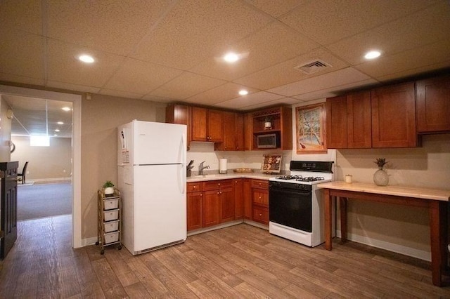 99 Elizabeth St, Agawam, MA 01030 - kitchen with white appliances, wood finished floors, light countertops, brown cabinetry, and open shelves