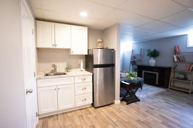 99 Elizabeth St, Agawam, MA 01030 - kitchen featuring freestanding refrigerator, light wood finished floors, white cabinetry, a fireplace, and a drop ceiling