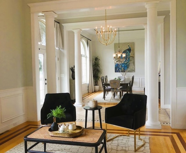 99 Elizabeth St, Agawam, MA 01030 - sitting room featuring ornate columns, a decorative wall, a chandelier, light wood finished floors, and a wainscoted wall