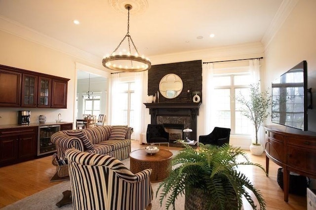 99 Elizabeth St, Agawam, MA 01030 - living room featuring wine cooler, a glass covered fireplace, bar area, a chandelier, and healthy amount of natural light