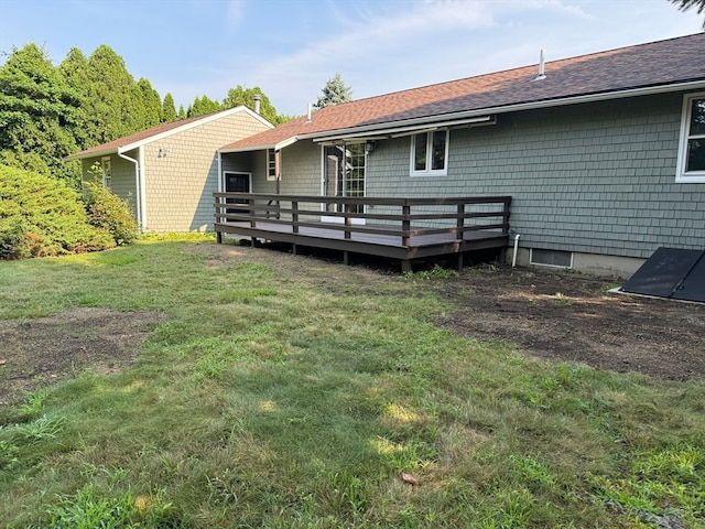 rear view of house with a deck and a lawn