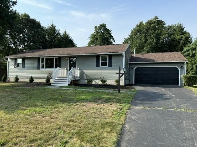 single story home featuring a garage and a front lawn