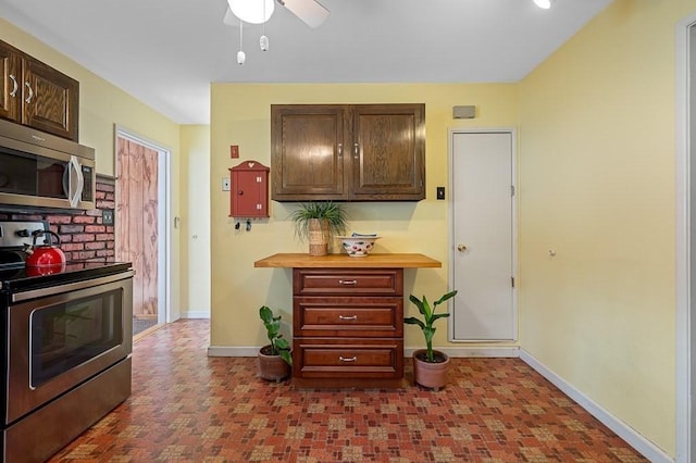 kitchen with stainless steel appliances, dark brown cabinetry, baseboards, and a ceiling fan