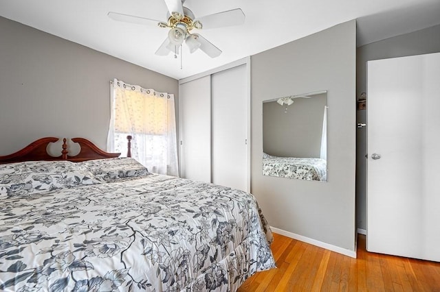 bedroom with a ceiling fan, baseboards, a closet, and wood finished floors