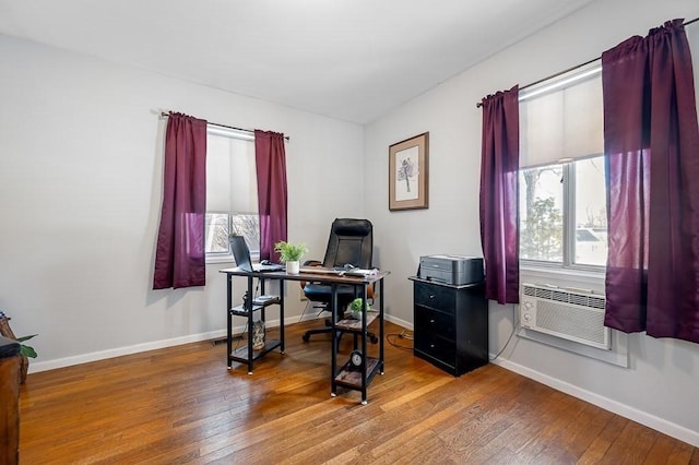 home office with cooling unit, hardwood / wood-style flooring, and baseboards