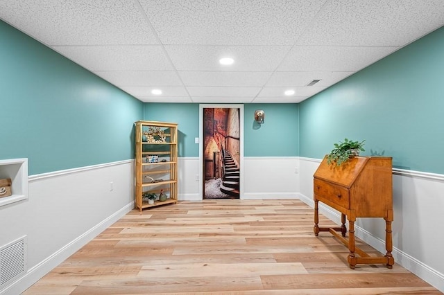 interior space with stairs, wainscoting, wood finished floors, and visible vents