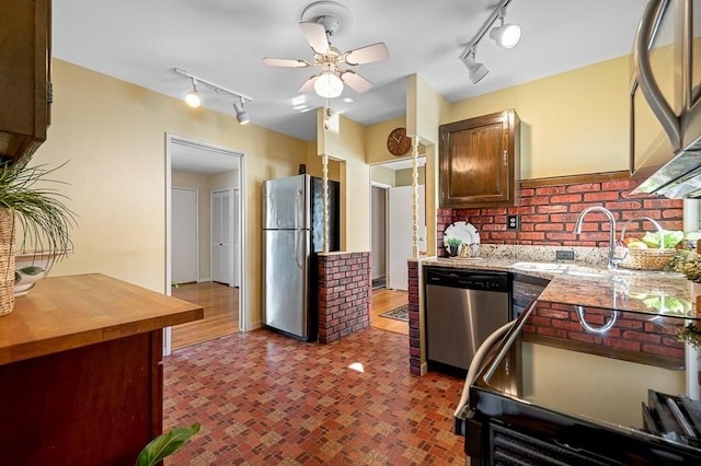 kitchen featuring stainless steel appliances, a sink, a ceiling fan, wooden counters, and rail lighting