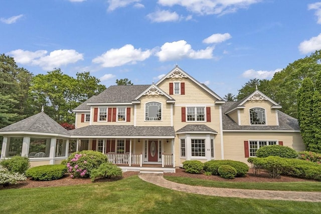 32 Bulkley Rd, Sudbury, MA 01776 - victorian home featuring a porch, roof with shingles, and a front yard