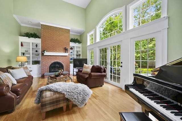 32 Bulkley Rd, Sudbury, MA 01776 - living room with a towering ceiling, a fireplace, wood finished floors, and crown molding
