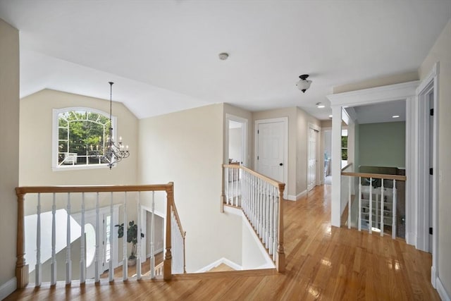 32 Bulkley Rd, Sudbury, MA 01776 - corridor featuring an upstairs landing, wood finished floors, a chandelier, baseboards, and vaulted ceiling