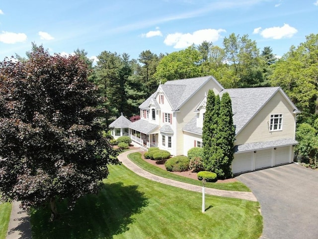 32 Bulkley Rd, Sudbury, MA 01776 - view of front facade with an attached garage, asphalt driveway, a shingled roof, and a front lawn