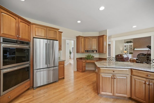 32 Bulkley Rd, Sudbury, MA 01776 - kitchen with appliances with stainless steel finishes, light wood-style floors, light stone counters, brown cabinets, and recessed lighting