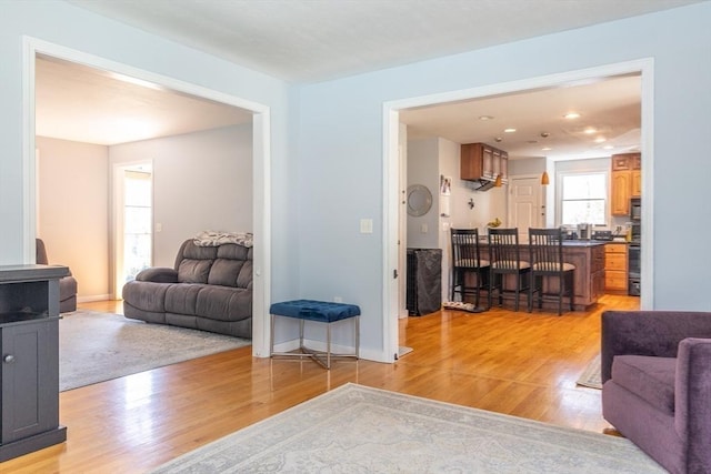 living room with light wood-type flooring and recessed lighting