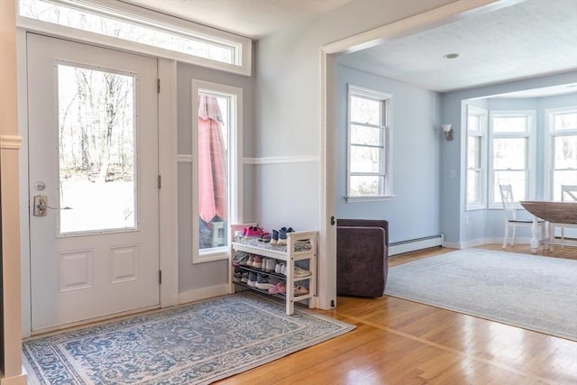 entryway with baseboard heating and wood finished floors
