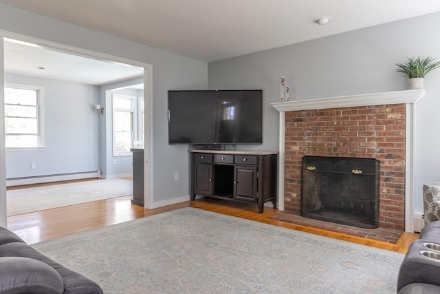 living room with baseboards, a brick fireplace, wood finished floors, and baseboard heating