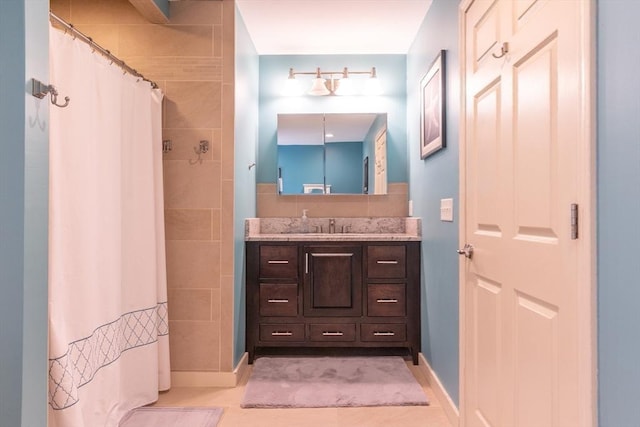 full bath featuring a shower with curtain, tile patterned floors, baseboards, and vanity