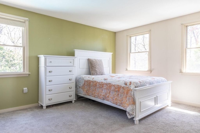 carpeted bedroom with baseboards and multiple windows