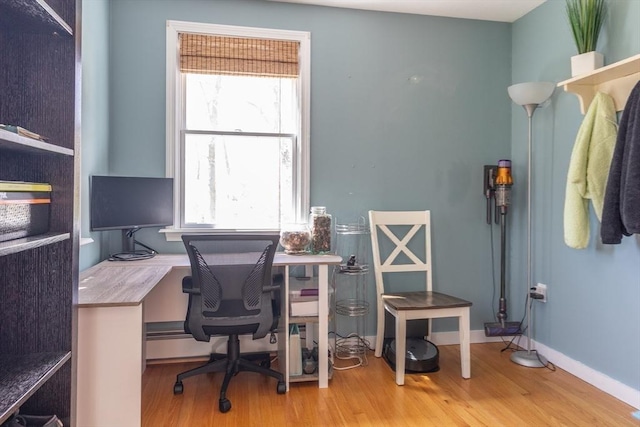 office with a baseboard heating unit and wood finished floors