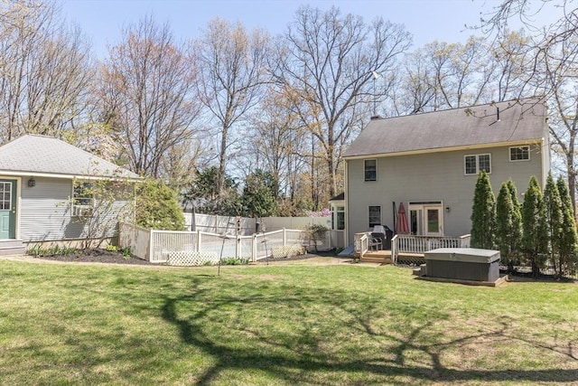 view of yard with a hot tub, a wooden deck, and fence