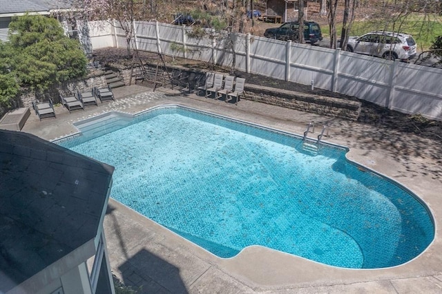 view of swimming pool featuring a fenced in pool, a fenced backyard, and a patio area