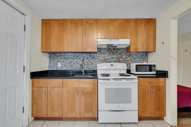 kitchen featuring tasteful backsplash, sink, light tile patterned flooring, and white appliances