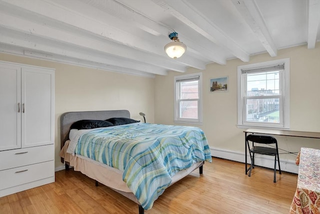 bedroom featuring beam ceiling, light hardwood / wood-style floors, and a baseboard heating unit