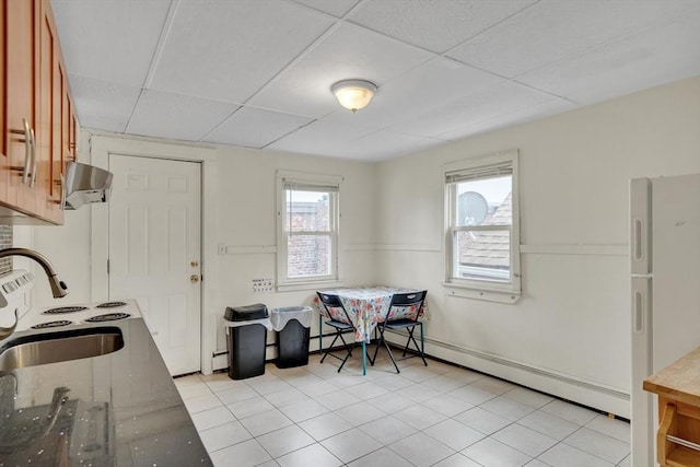 tiled dining area featuring a drop ceiling and sink