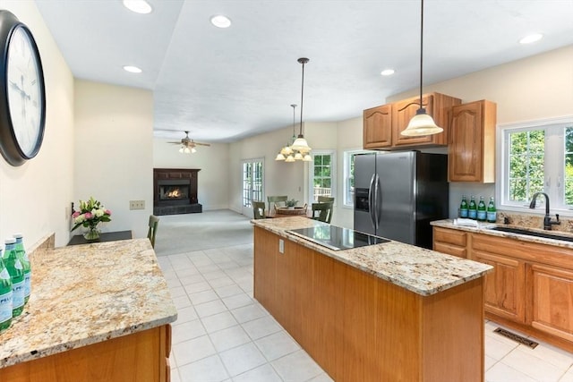 31 Swing Dr, Berkley, MA 02779 - kitchen featuring stainless steel refrigerator with ice dispenser, black electric stovetop, a kitchen island, a warm lit fireplace, and ceiling fan