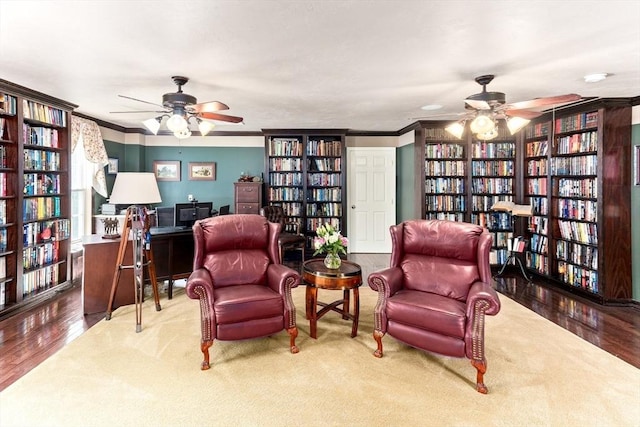 31 Swing Dr, Berkley, MA 02779 - sitting room with wall of books, ceiling fan, wood finished floors, and ornamental molding
