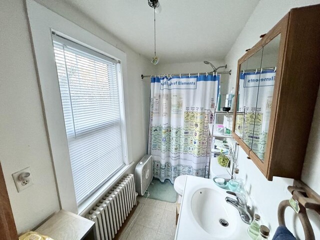 bathroom featuring radiator, toilet, radiator heating unit, curtained shower, and vanity